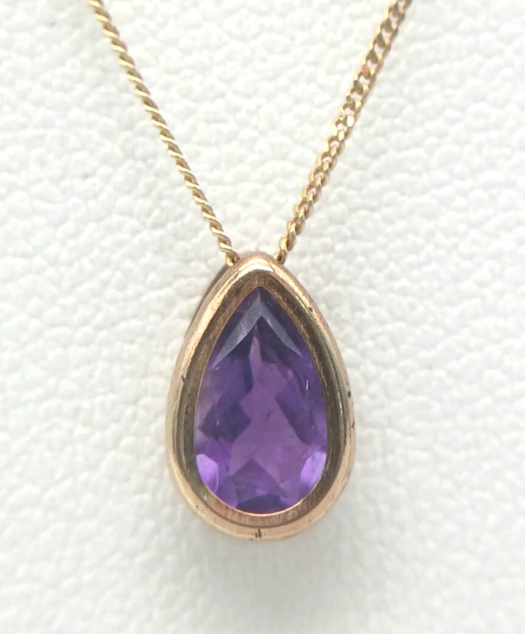 A Pretty 9k Yellow Gold and Amethyst Pendant Necklace. 46cm Lengthchain. The Pendant is set with a 7 x 5mm Tear Drop Cut Top Colour Amethyst,approximately 0.75 carat. The Necklace has a gross weight of 1.21 Grams.