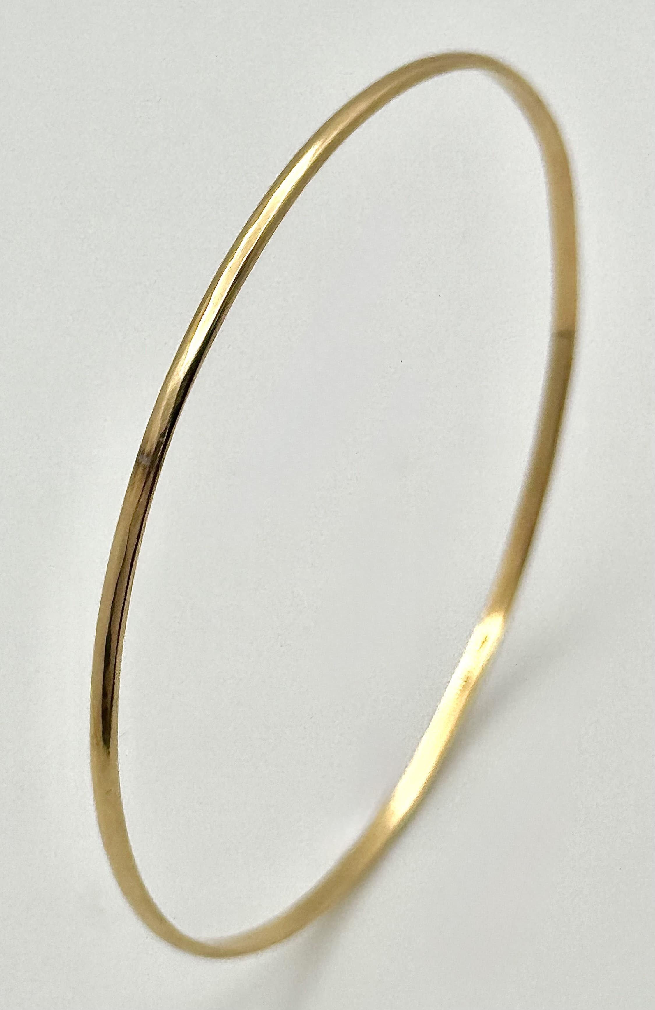 A 14K Yellow Gold Thin Bangle. 3mm width. 62mm inner diameter. 5.05g.