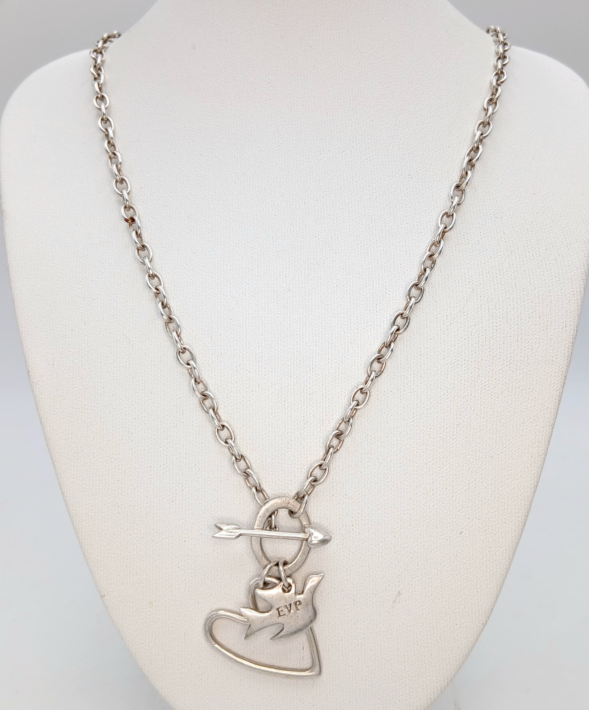 A 925 Sterling Silver Necklace with Dove, Heart Charm and Heart Arrow Toggle Clasp Detail. Total weight 18.47g. Approx 40cm chain length.