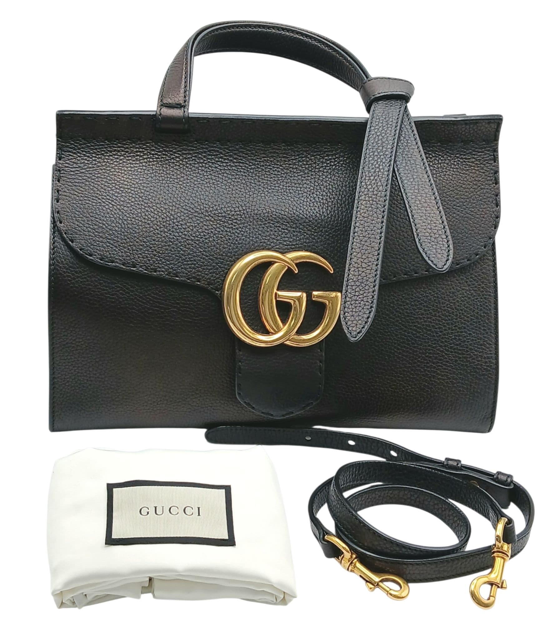 A Gucci GG Marmont Black Leather Top Handle Bag. Black leather exterior with gold-toned hardware, single top handle, detachable shoulder strap and push lock closure. Beige textile interior with one main compartment, a zipped side pocket and opened side pockets. Approx 31cm length x 20cm height x 13cm depth. Comes with a dust cover and certificate of authenticity. Some signs of wear and stains to the leather and scratches to the hardware. Please see photos or request a condition report. Ref: 28651.