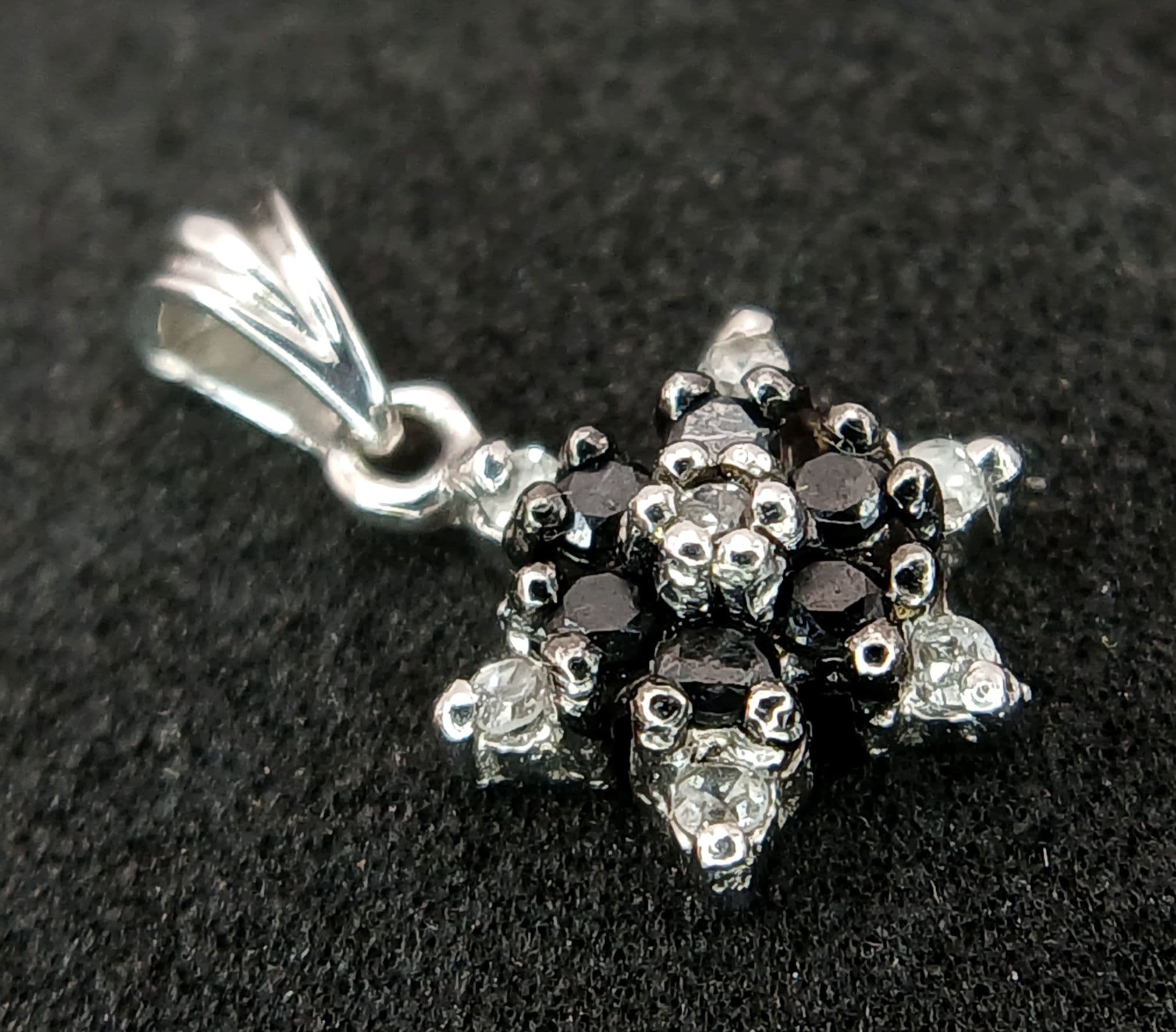 A Vintage 9k (Tests minimum 9k) White Gold Round Cut Black and White Diamond Pendant. 1.2cm Drop, 8mm Width. Gross weight 0.59 grams