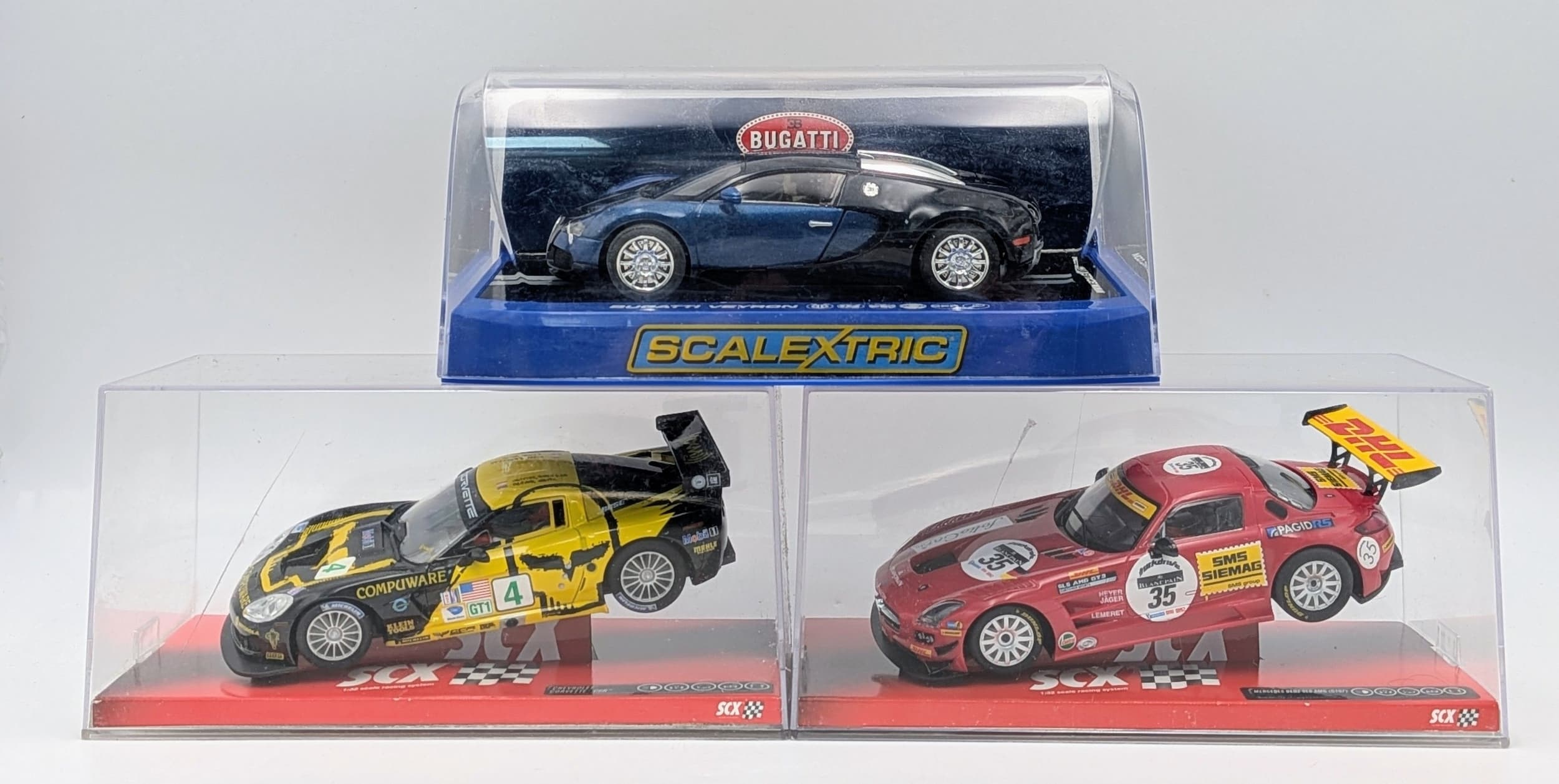 Three Scalextric cars. A Bugatti Veyron, A Corvette and a Mercedes sls. All in their original plastic boxes. Never been out and used, so as new, Some marks to the plastic boxes from storage.