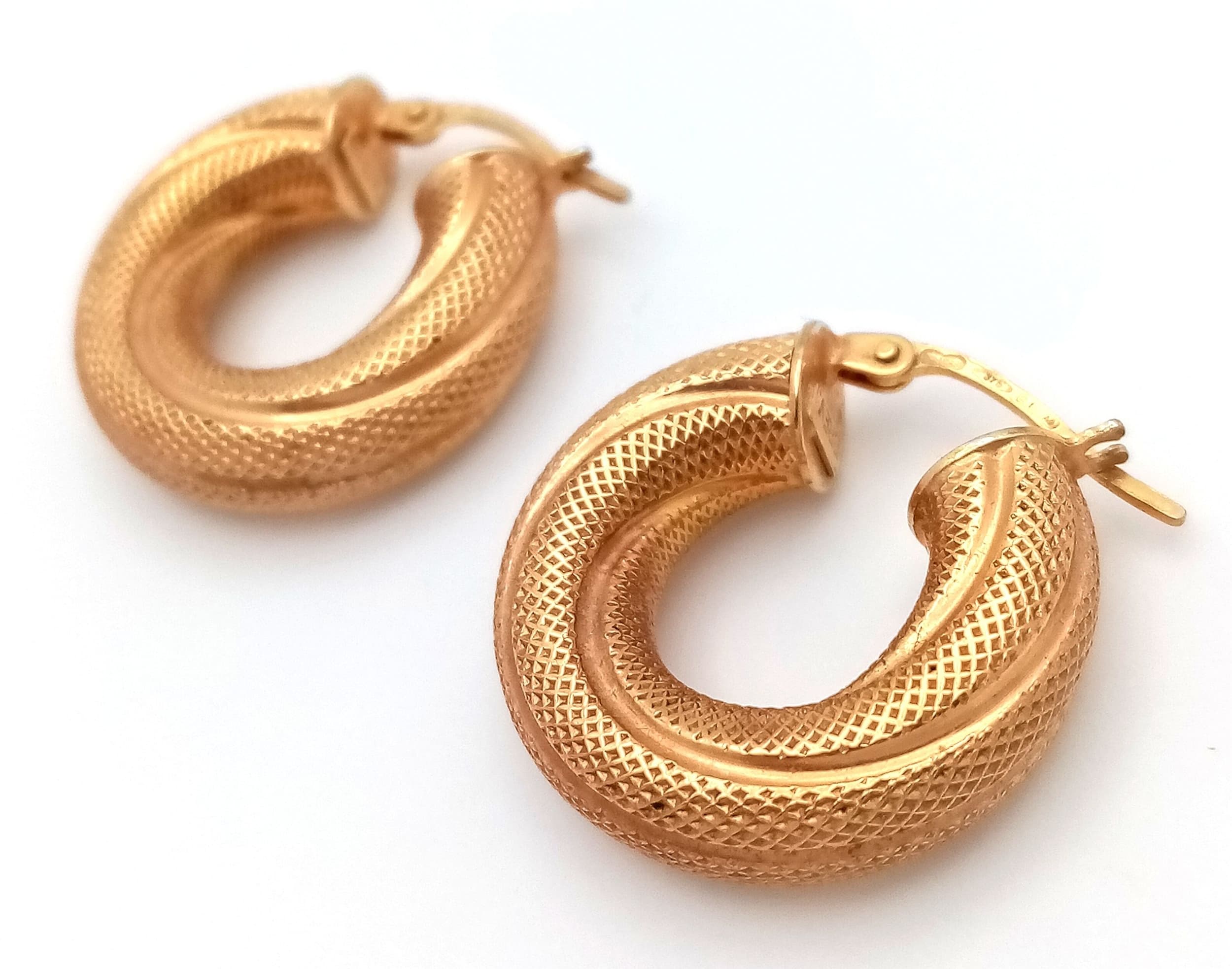 A PAIR OF CHUNKY PATTERNED HOOP EARRINGS IN 9K GOLD . 3.6gms
