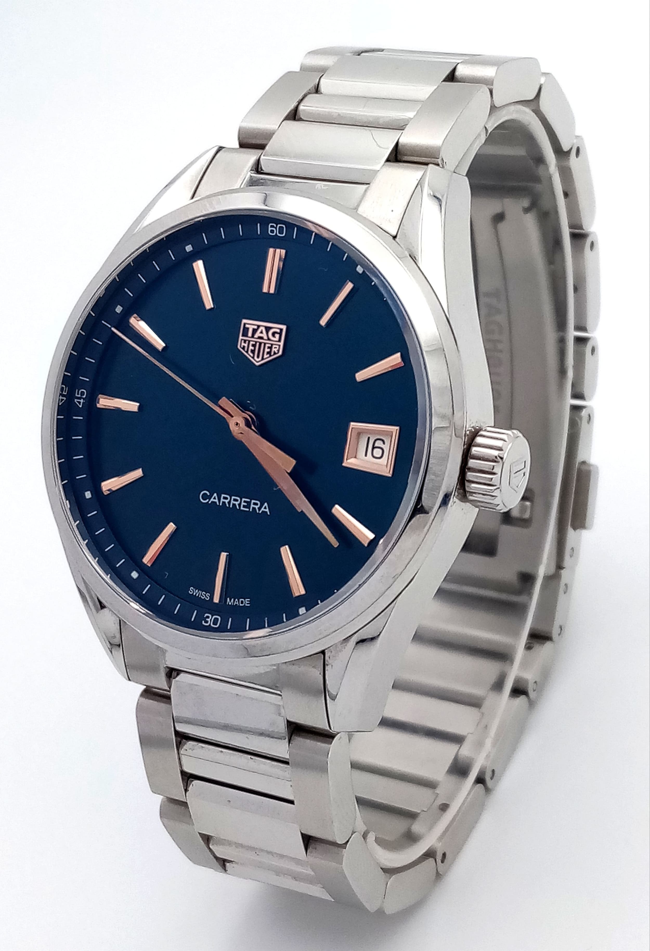 A Tag Heuer Carrera Quartz Watch. Model WBK1312. Stainless steel bracelet and case - 36mm. Deep blue dial with date window and rose gold tone baton markers. In very good condition and working order. Comes with box, spare links and papers. Ref: 028615.