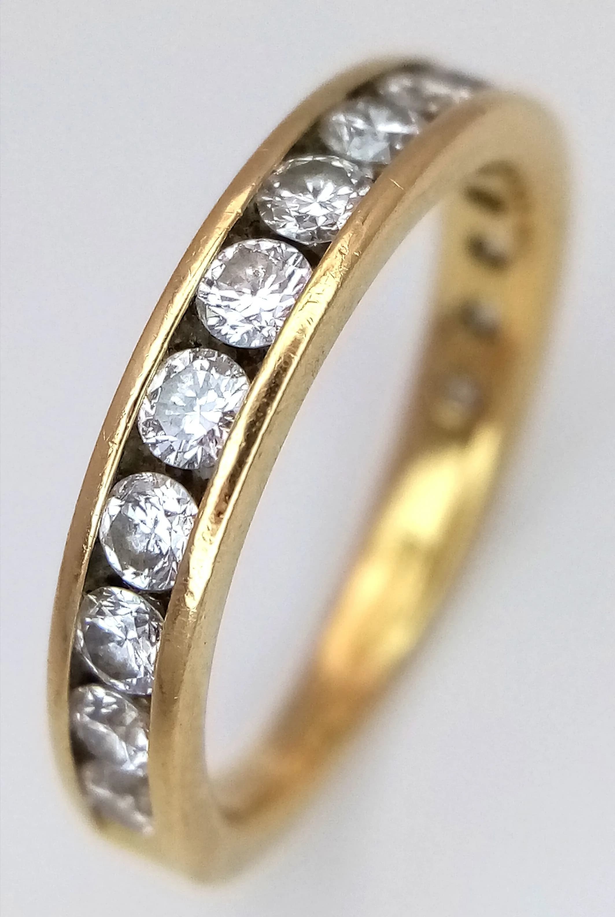 AN 18K YELLOW GOLD, DIAMOND SET, 3/4 SET ETERNITY RING. 0.75CTW. 3G, SIZE K. SC 5105