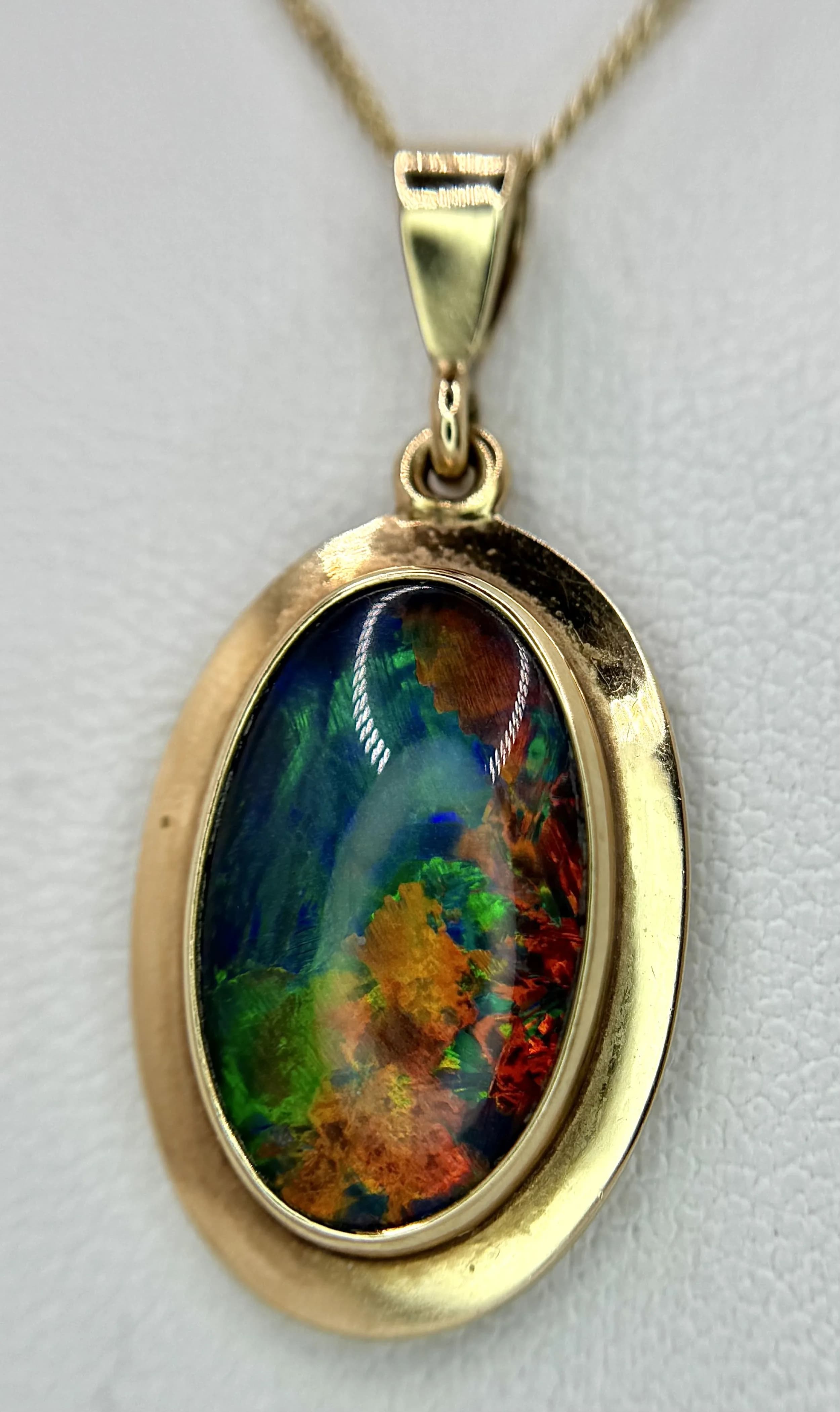 An Attractive 9k Yellow Gold Opal Pendant Necklace. 46cm Length Chain. The Pendant measures a 2.9cm drop and is 1.4cm Wide being set with an Oval Cut 15 x 9mm Opal with excellent colouration. Understood to be anAustralian Opal. Gross weight 3.76 grams