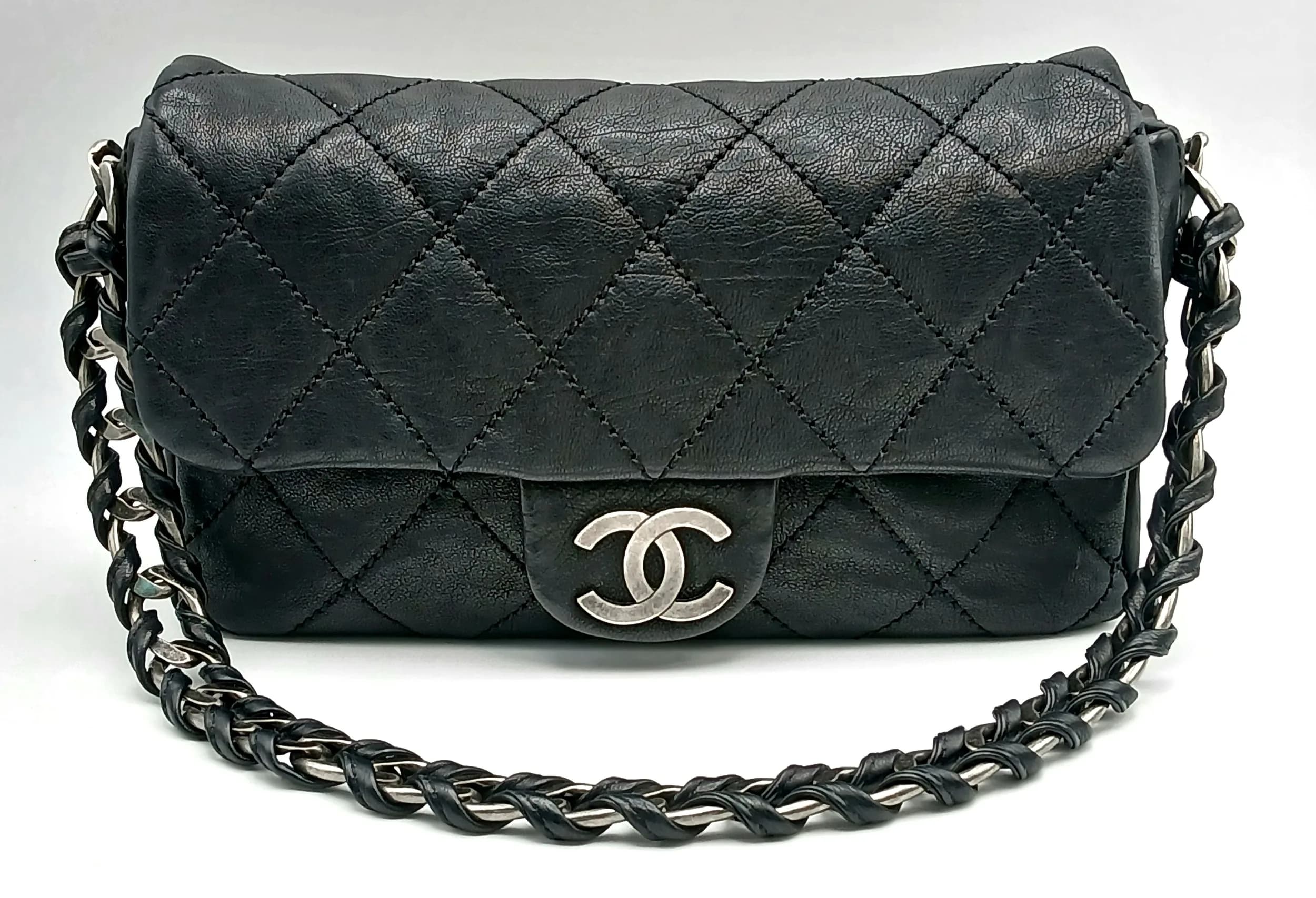 A Chanel Glazed Caviar Quilted Medium Modern Chain Flap Bag. Black diamond-quilted glazed caviar leather exterior with silver-toned hardware, leather-threaded chunky chain shoulder strap, and magnetic closure. Flap opens to a black leather interior with one main compartment, a zipped inner side pocket and an open inner side pocket. Comes with authenticity card, care booklet, dust cover bag and box. Approx 25.5cm length x 14.5cm height x 6cm depth. Sign of discolouration to the corners and the leather, few light white marks, but in good overall condition. Please see photos or request a condition report. Ref: 28644