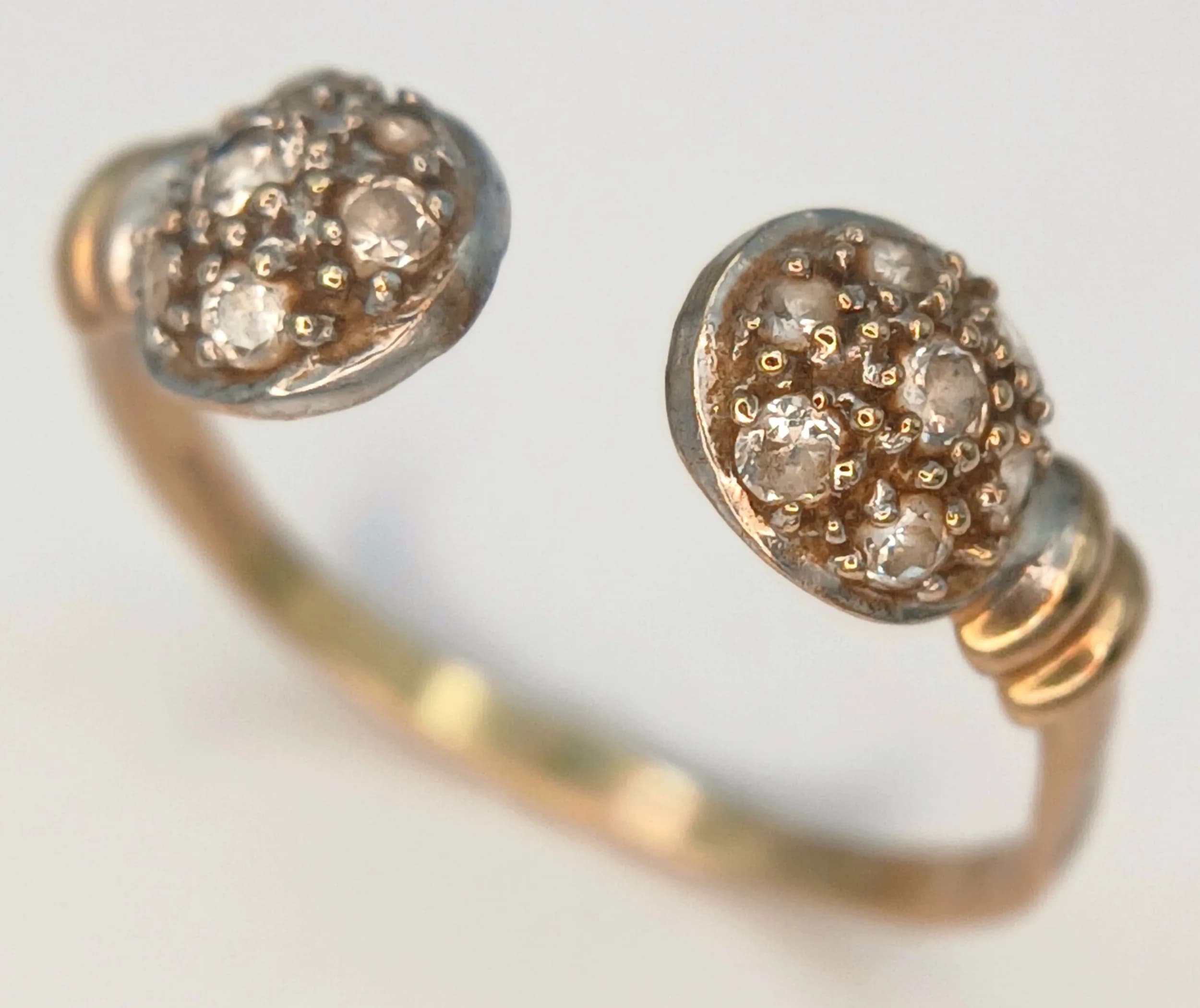 A 9K GOLD TORQUE RING WITH STONE SET ENDS . 1.4gms one size