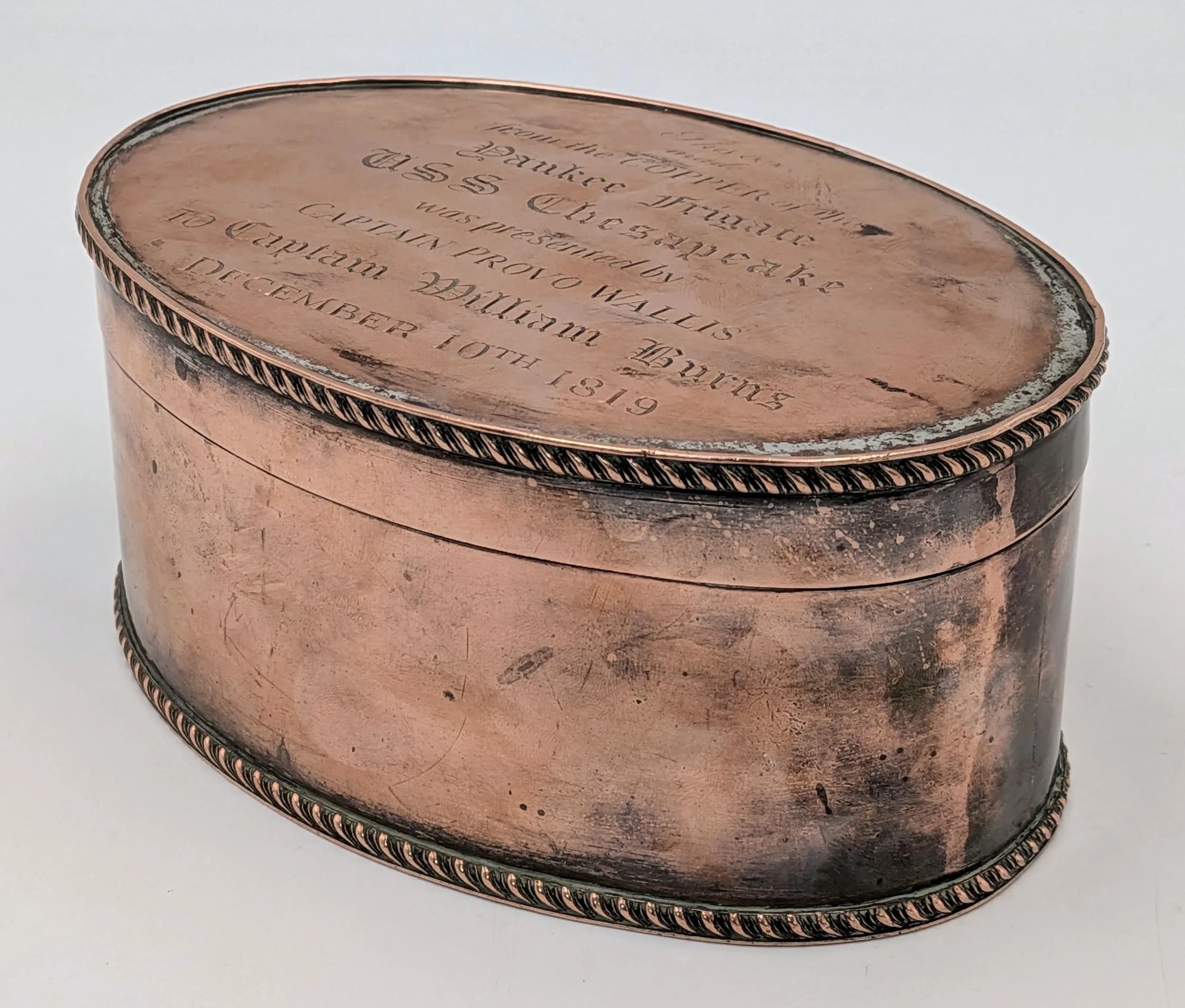 A War of 1812 USS Chesapeake Related Item - Fascinating Historical Piece. An oval copper plated box with the inscription: This box made from the copper of the Yankee frigate USS Chesapeake was presented by Captain Provo Wallis to Captain William Burns, December 10th 1819. 15cm x 11cm. 7cm height.
