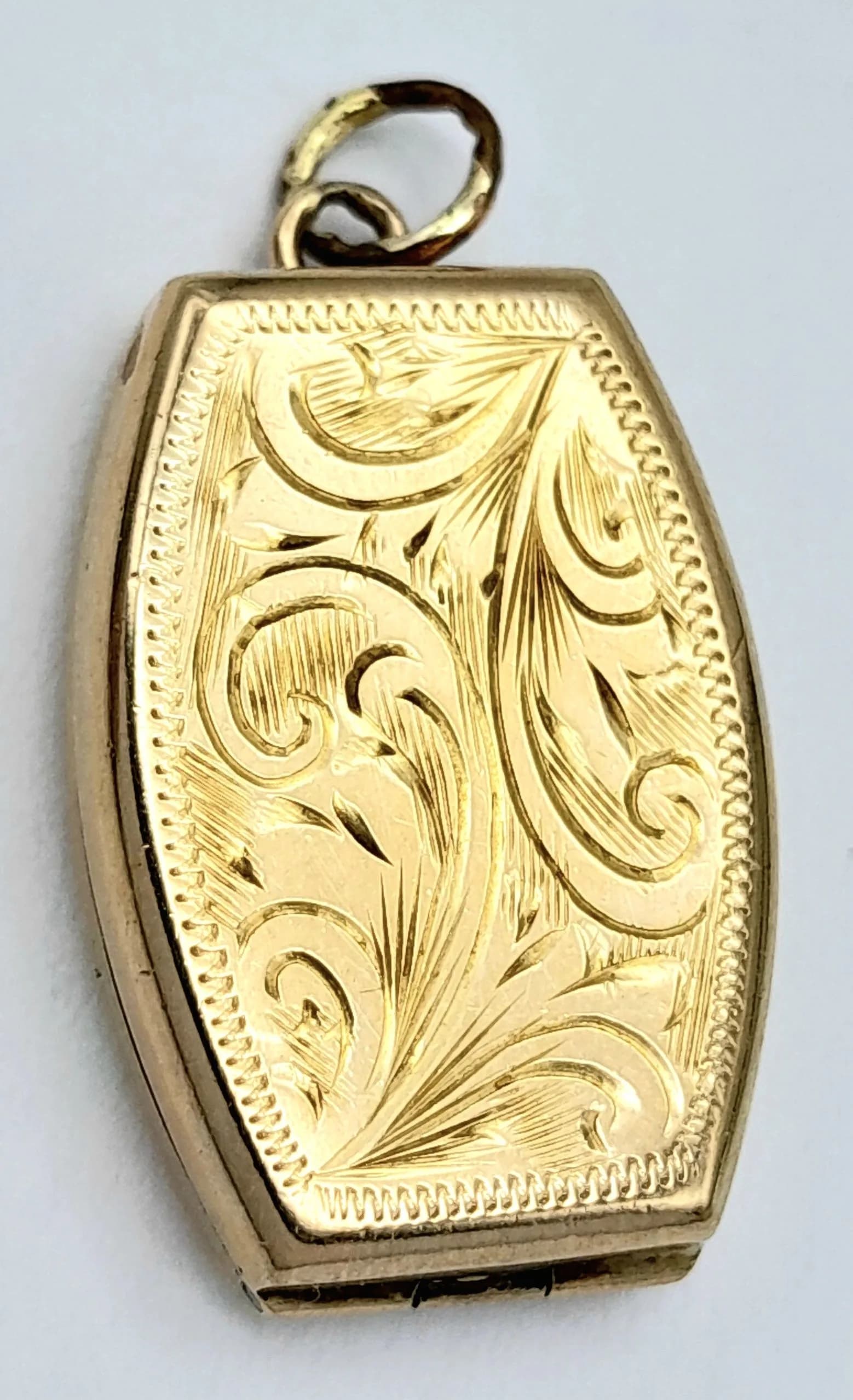 A 9K GOLD LOCKET PENDANT WITH DECORATED FRONT AND UNUSUAL SHAPE . 2.8gms