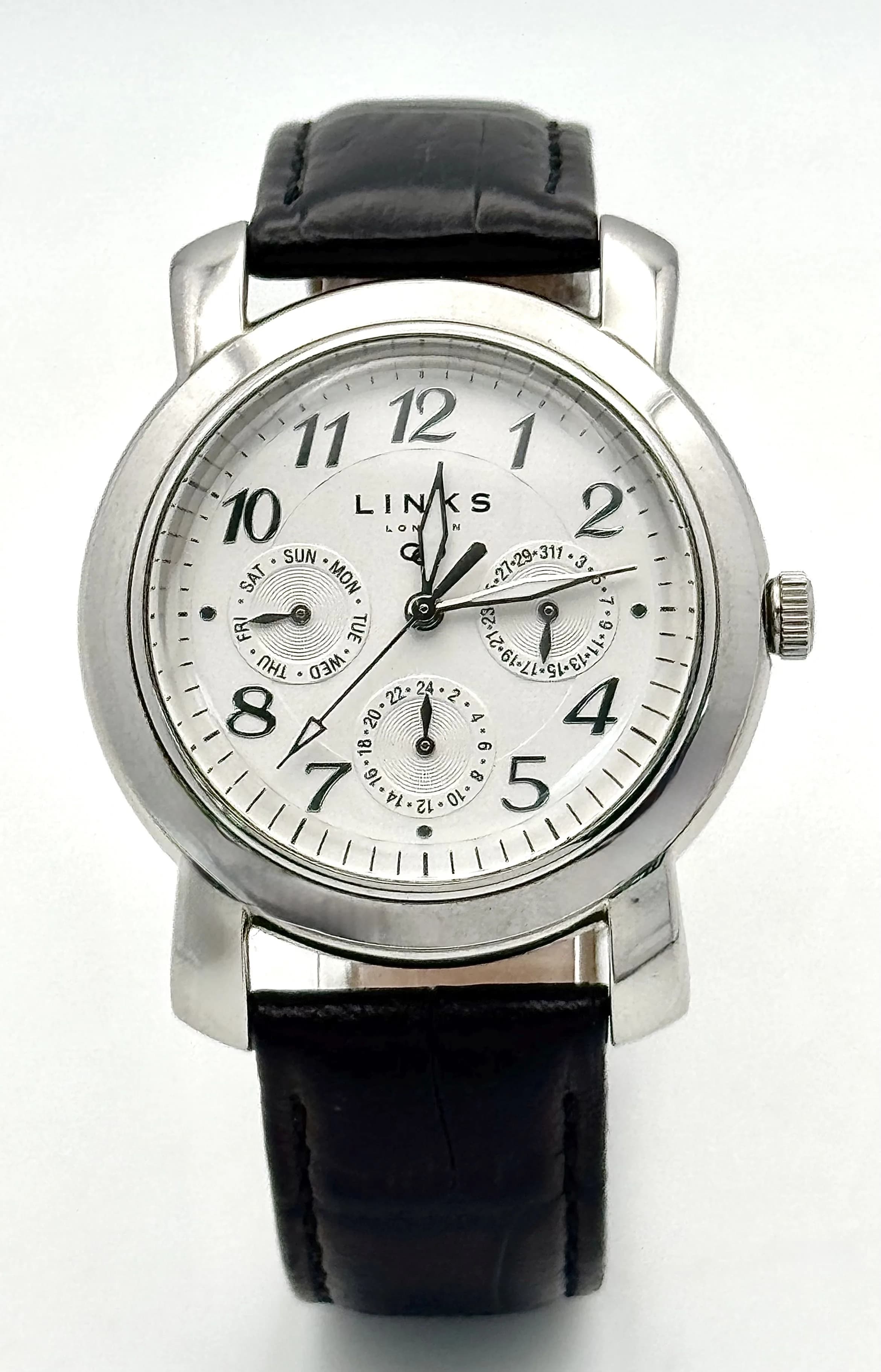 A Links of London Stylish Quartz Movement Gents Watch. Black leather strap. Stainless steel case - 40mm. White dial with three sub dials. New battery recently fitted - In working order. Ref: 029013