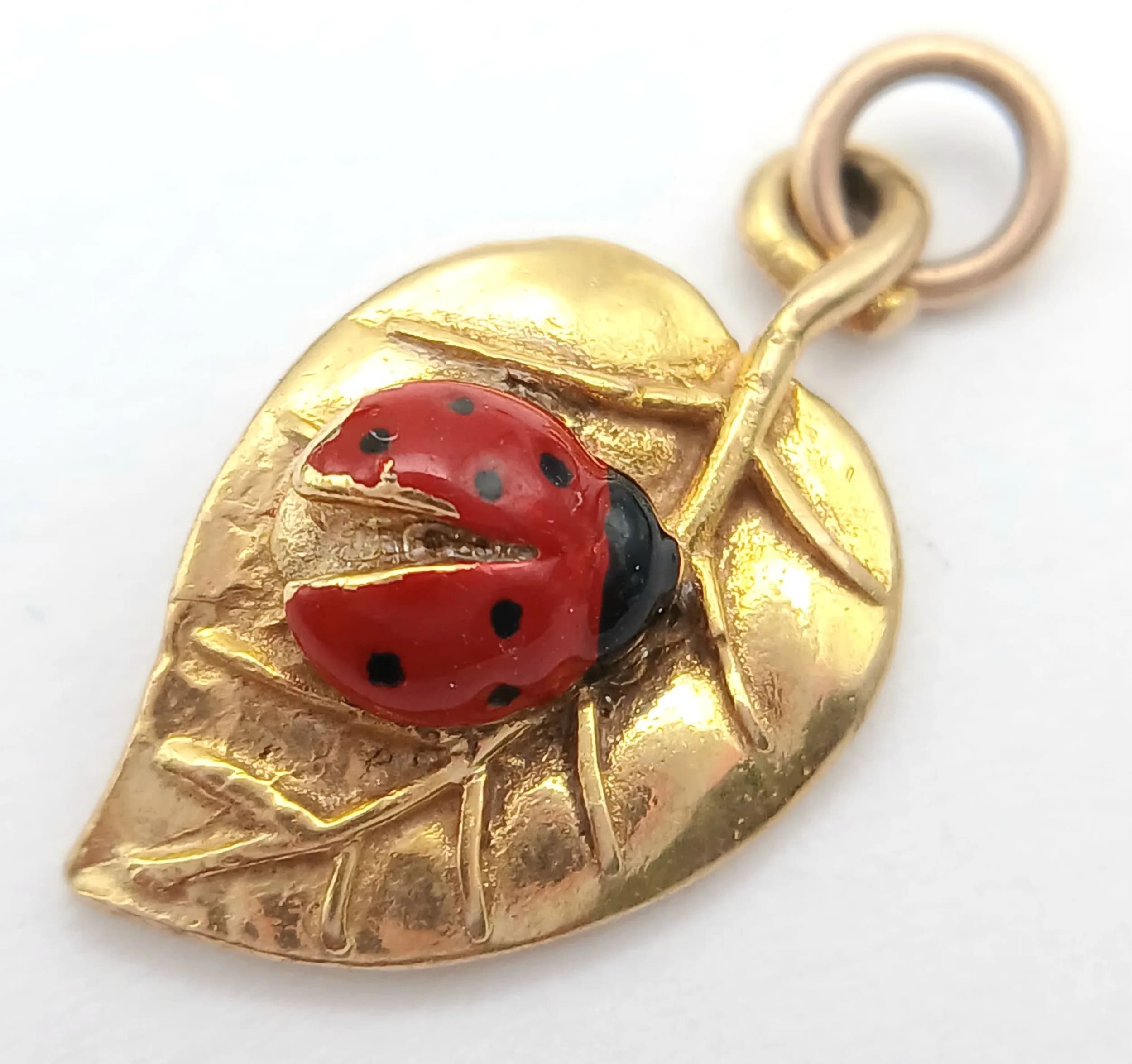 A 9K YELLOW GOLD, LEAF WITH AN ENAMELLED LADYBIRD ON IT, CHARM / PENDANT. 1.5G. SC 5029