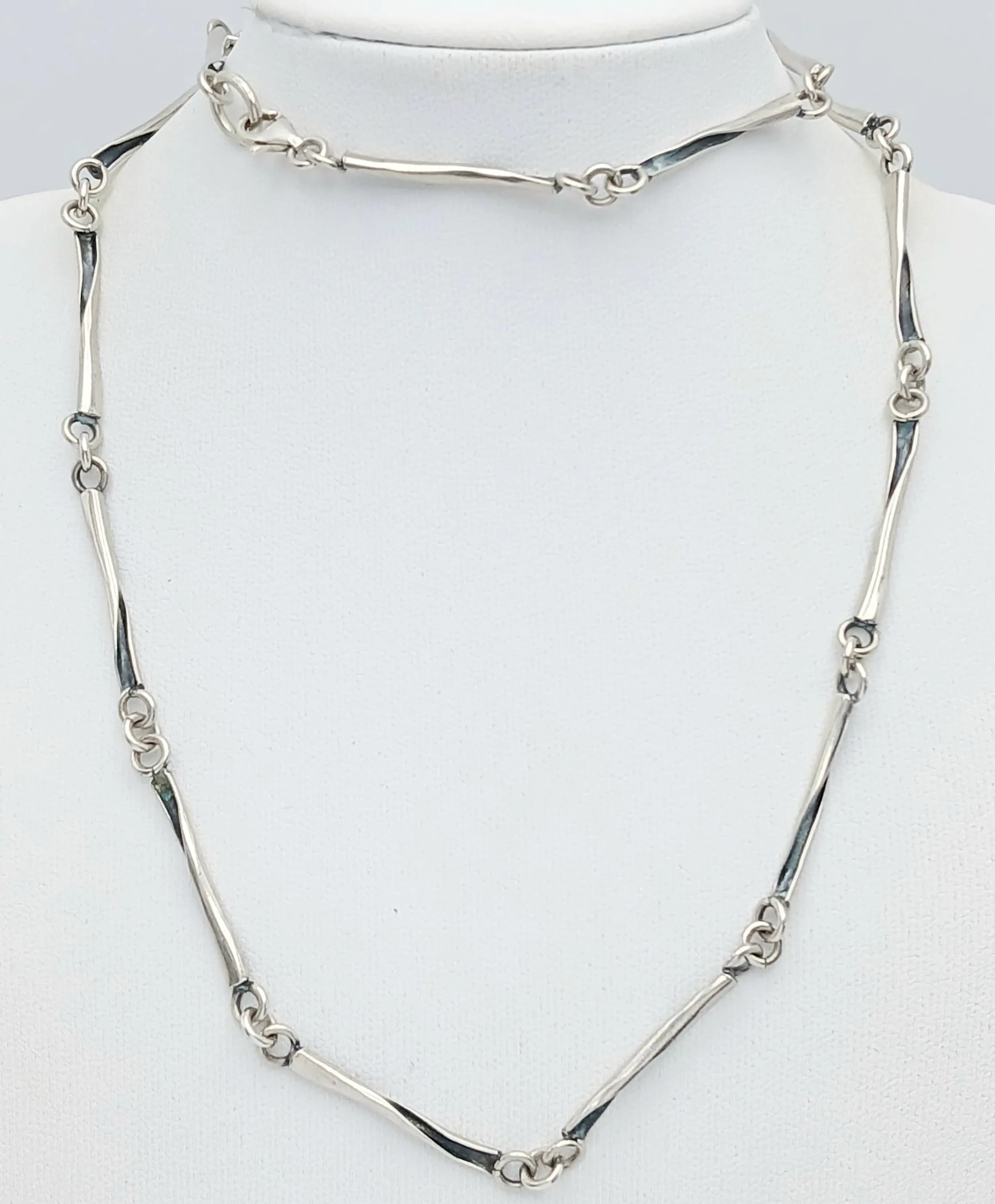 A Pretty 925 Silver Necklace. Featuring fine silver bar links with decorative knot style station details. Approx 56cm length. Gross weight 15.54 grams.