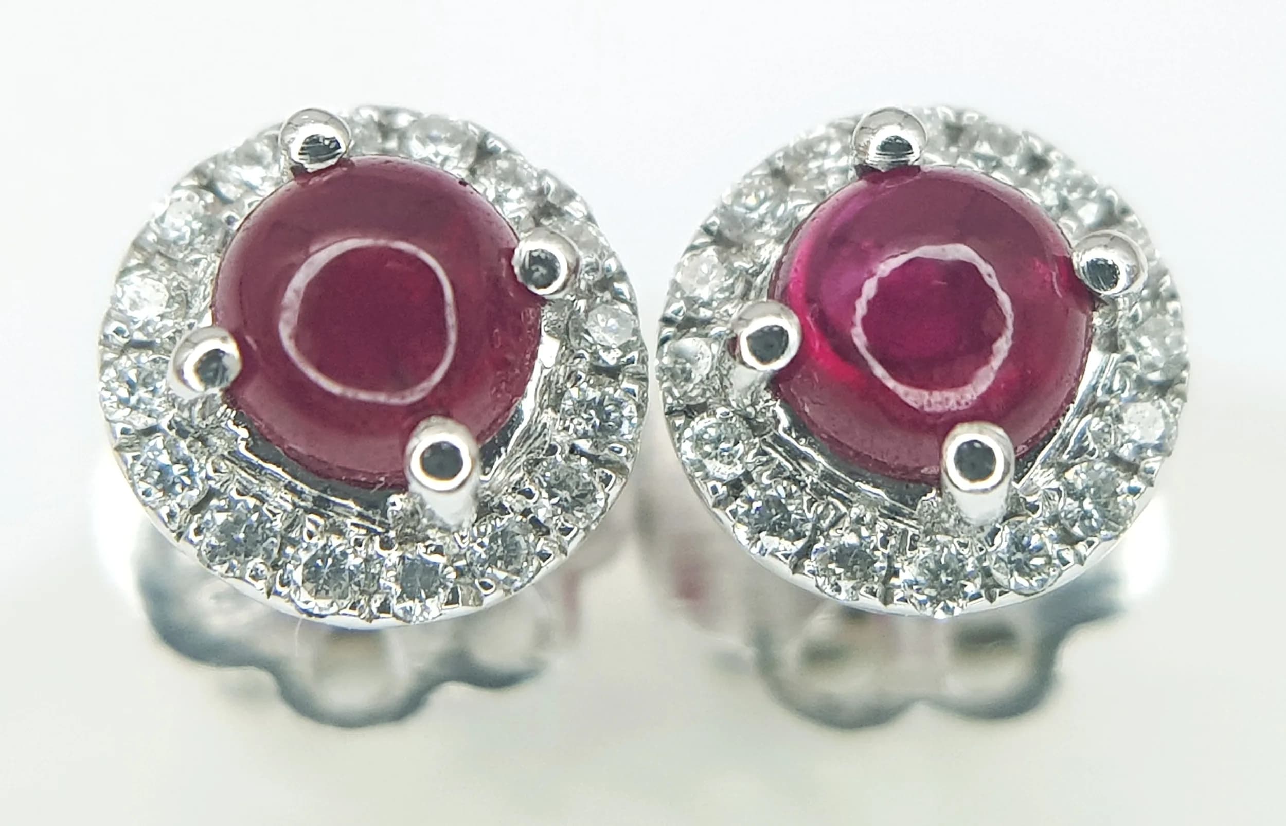 A Pair of 18K White Gold, Ruby Cabochon and Diamond Stud Earrings. 2.5g total weight. MT44.