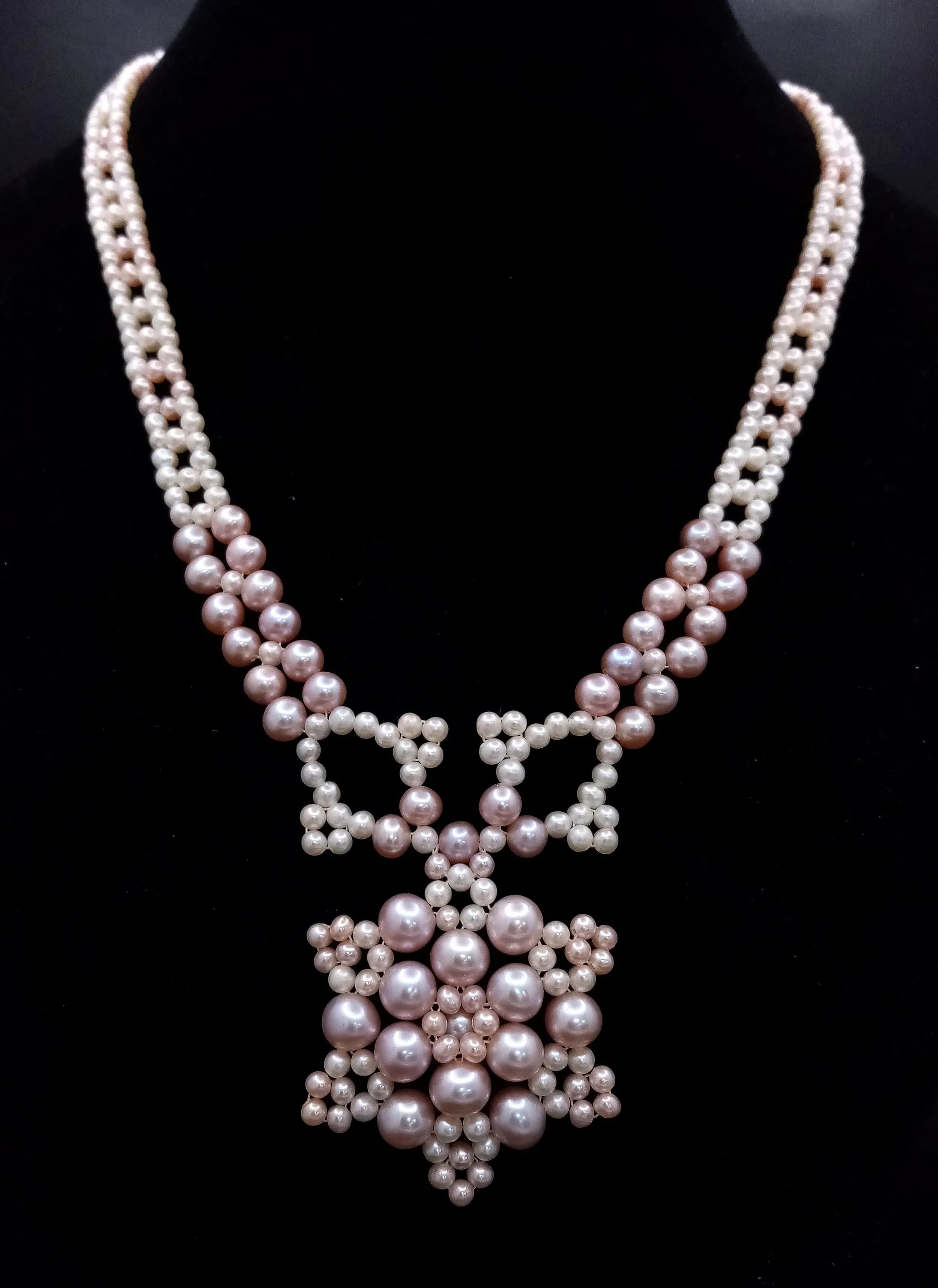 A well crafted Pink and Cream freshwater Pearl Statement Necklace. Comprising pink and cream pearls in a decorative bib design with an ornate snowflake-style pendant. Approx 40cm (excluding clasp). Please see photos for details.