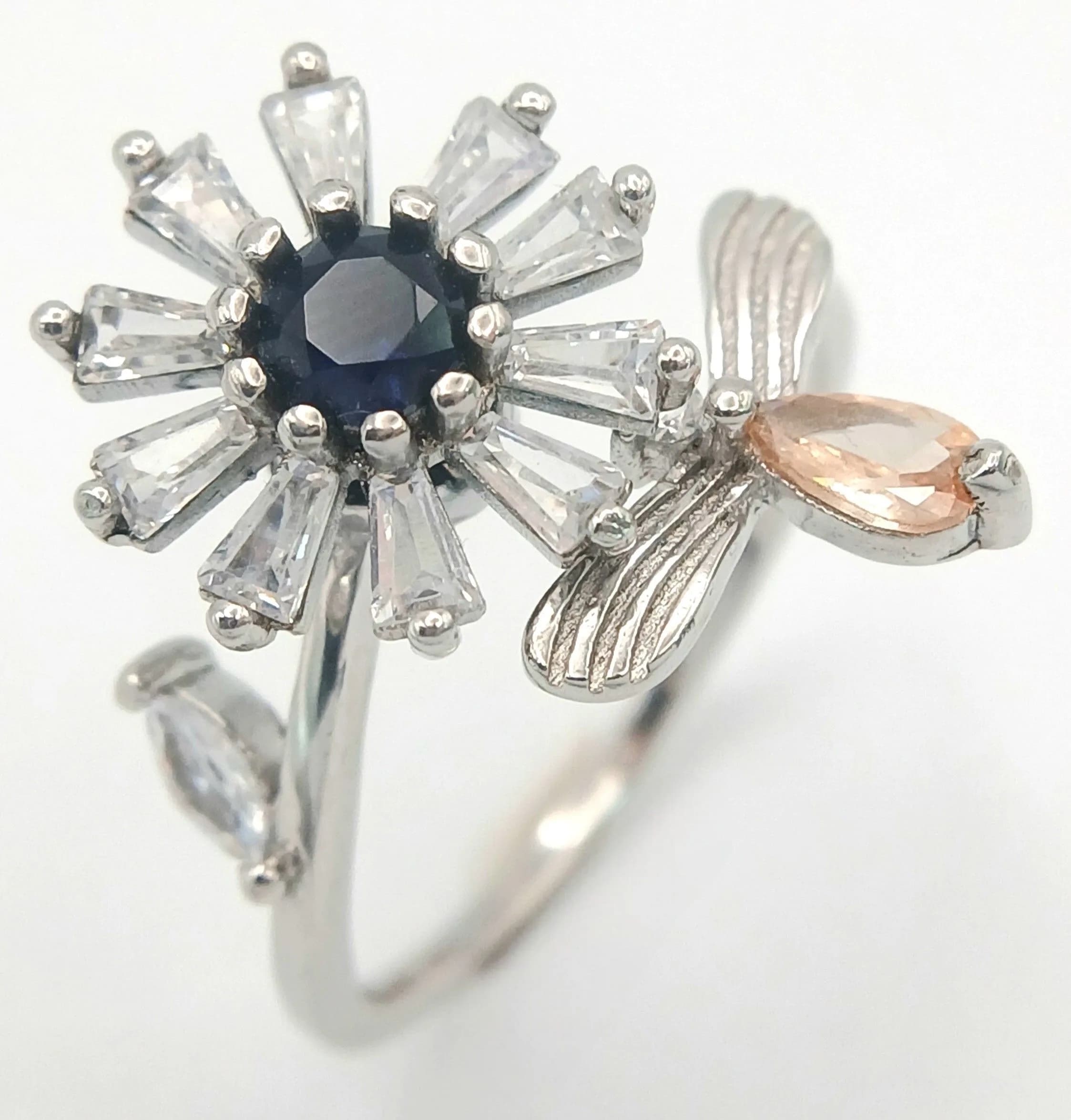 An Unique Sterling Silver Gem Set Flower and Bug Spinning Ring. Size P. The Ring measures 2cm Wide at the crown with the flower part of the ring being able to spin. Gross weight 3.15 grams.
