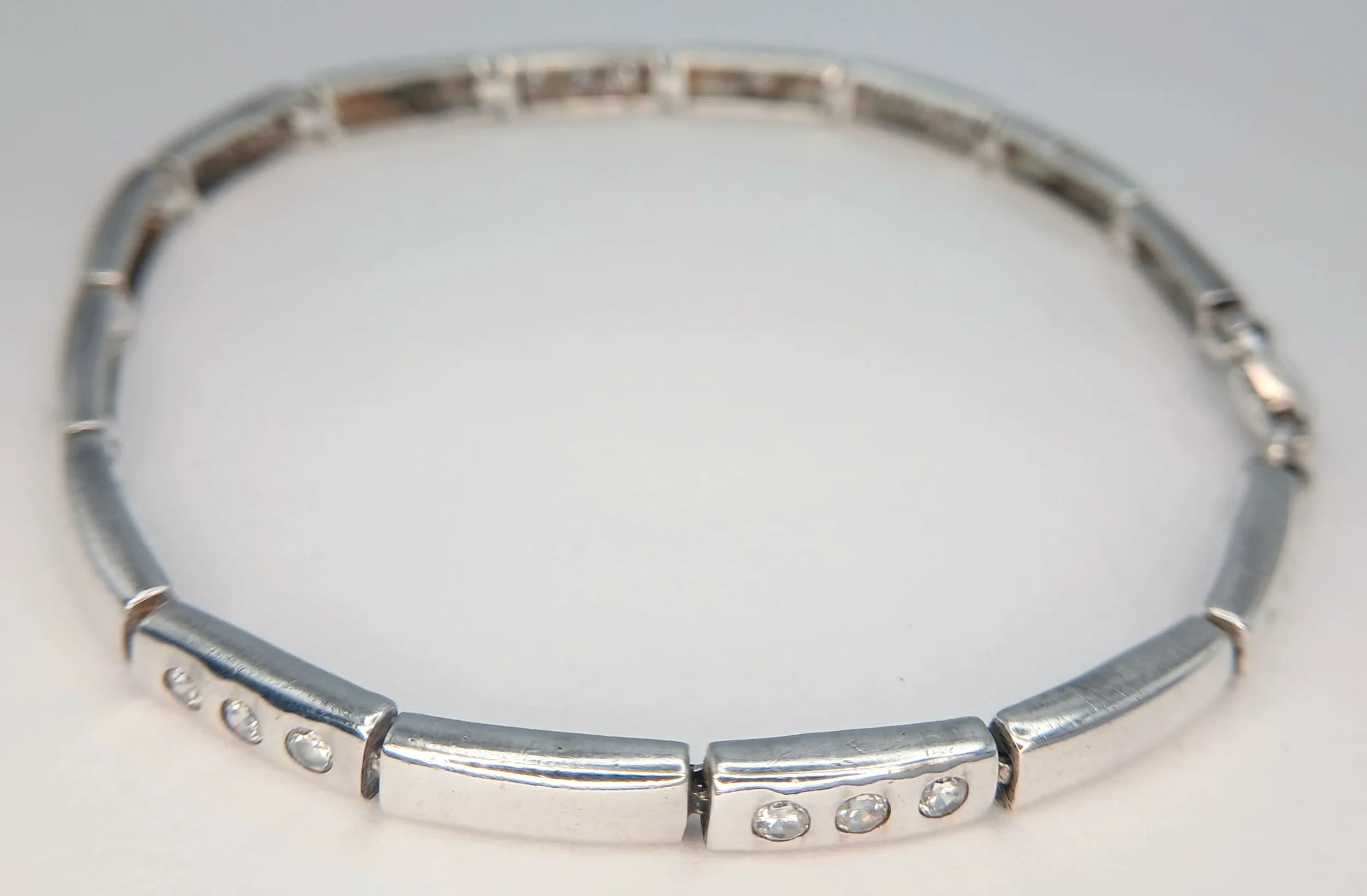 A Beautiful 925 Silver CZ Stone Set Bracelet. Featuring polished silver rectangular links set with small round CZ stones. Approx 18cm length. Total weight 9.49 grams.