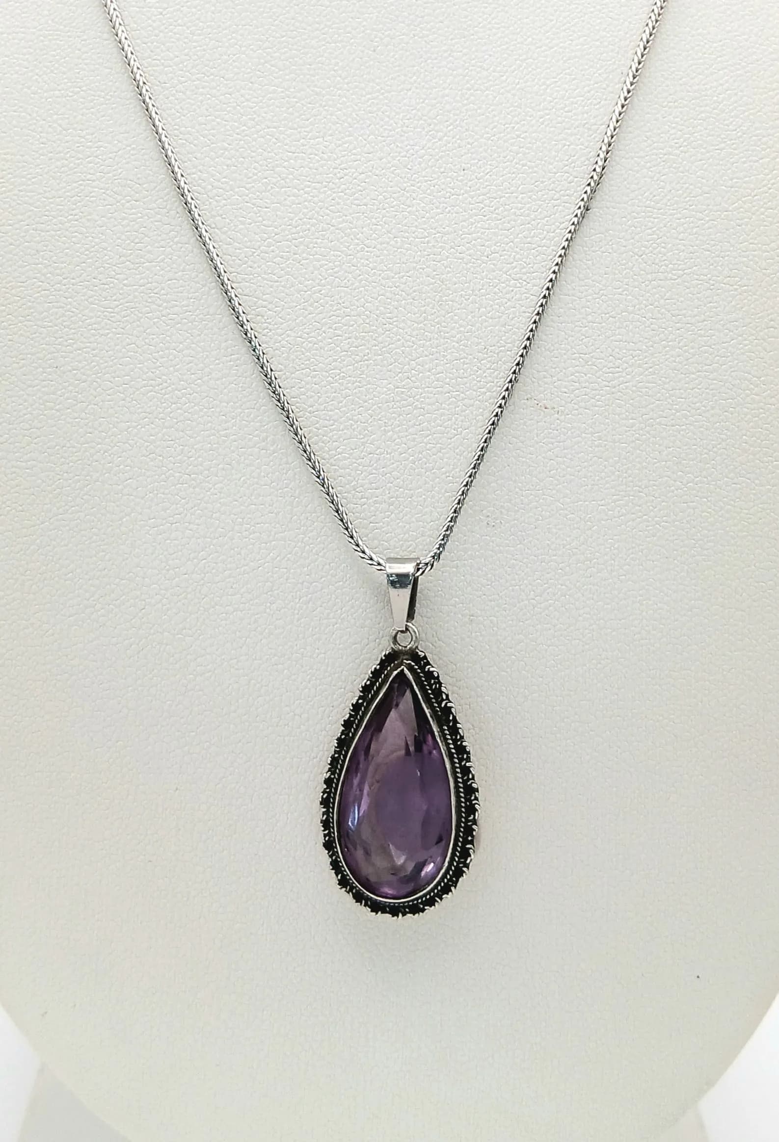 An Attractive 925 Silver Amethyst Pendant Necklace. Set with a pear cut amethyst in a decorative silver mount on a fine silver chain. Chain approx 45cm length. Pendant approx 2cm x 1cm. Total weight 6.83 grams.
