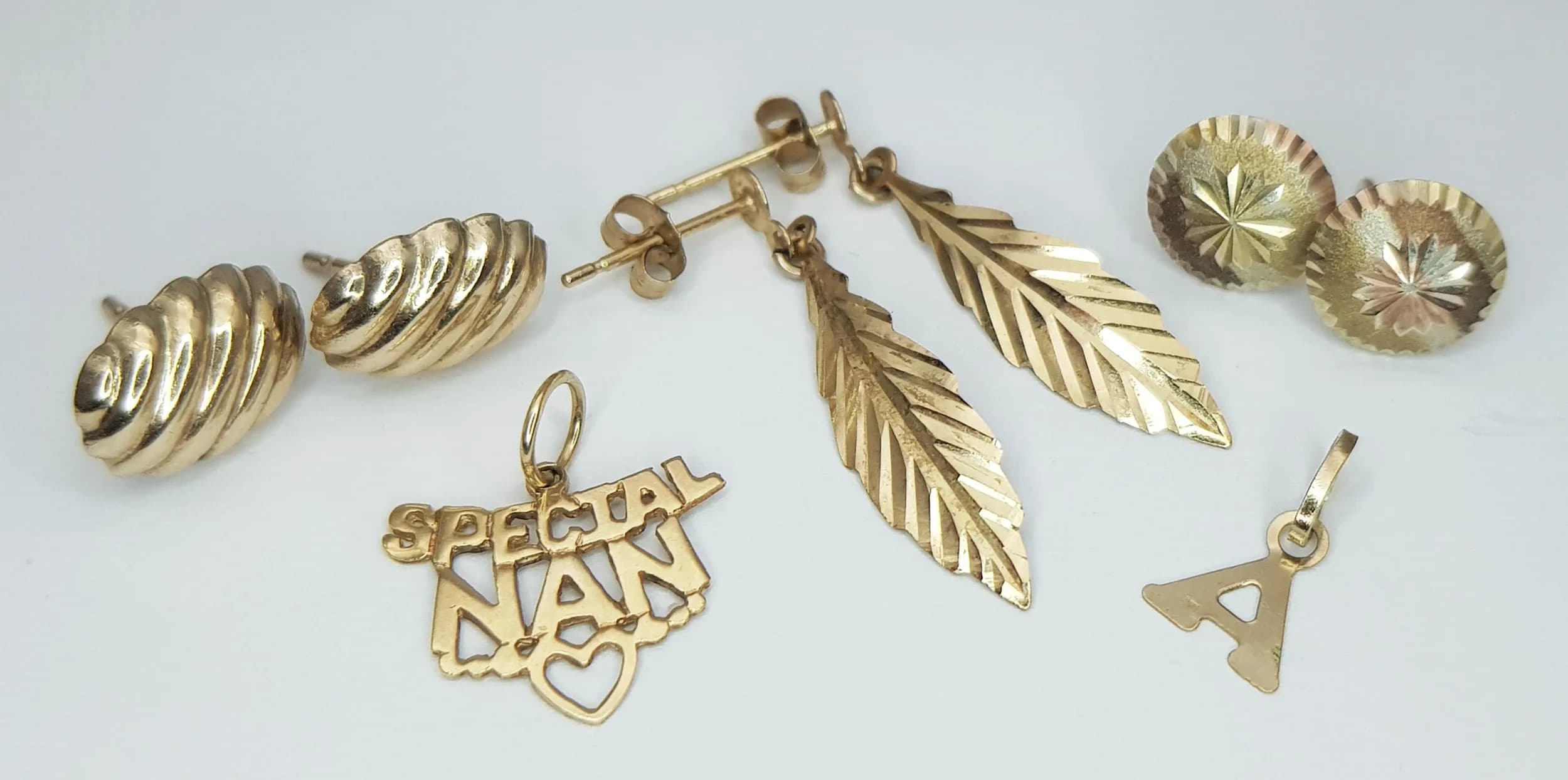 A 9K Gold Mix. Three pairs of earrings (two without backs) and two small pendants. 1.8g total weight.