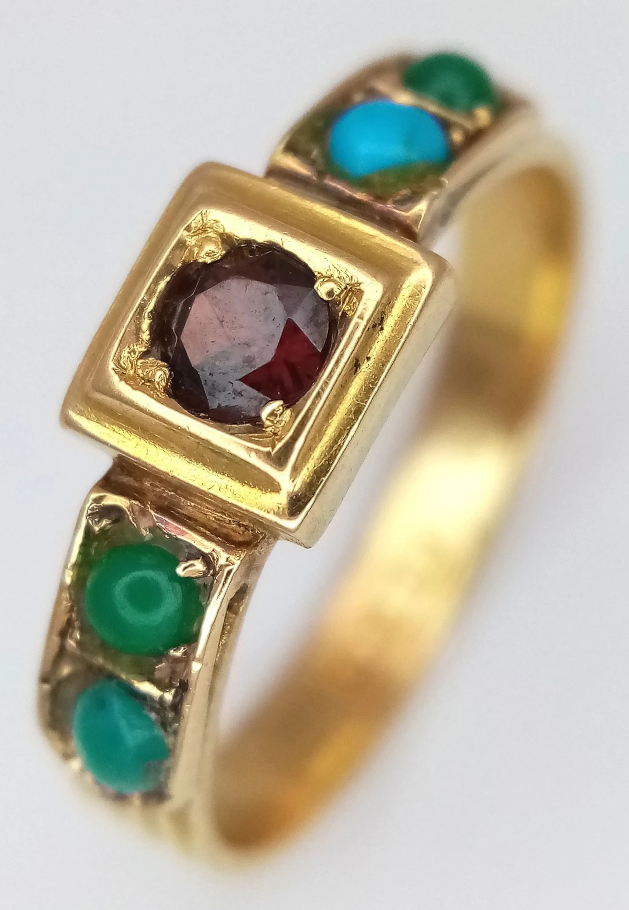 An 18k yellow gold turquoise garnet ring, 2mm turquoise size, 3mm garnet size, 2.7g total weight, ring size L