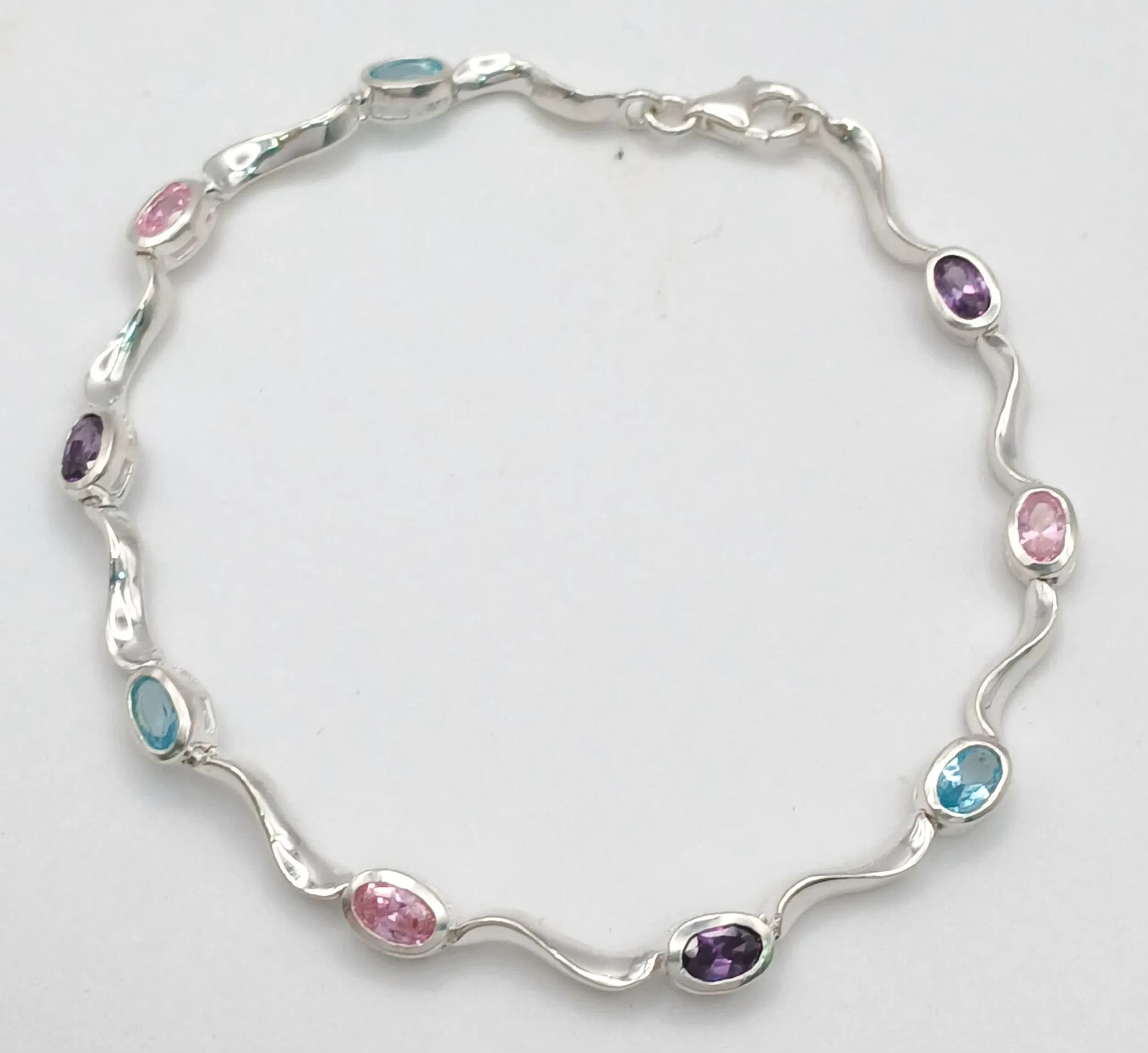 A Sterling Silver Coloured Stone Set Wave Design Tennis Bracelet 18.5cm Length. Gross weight 6.87 grams