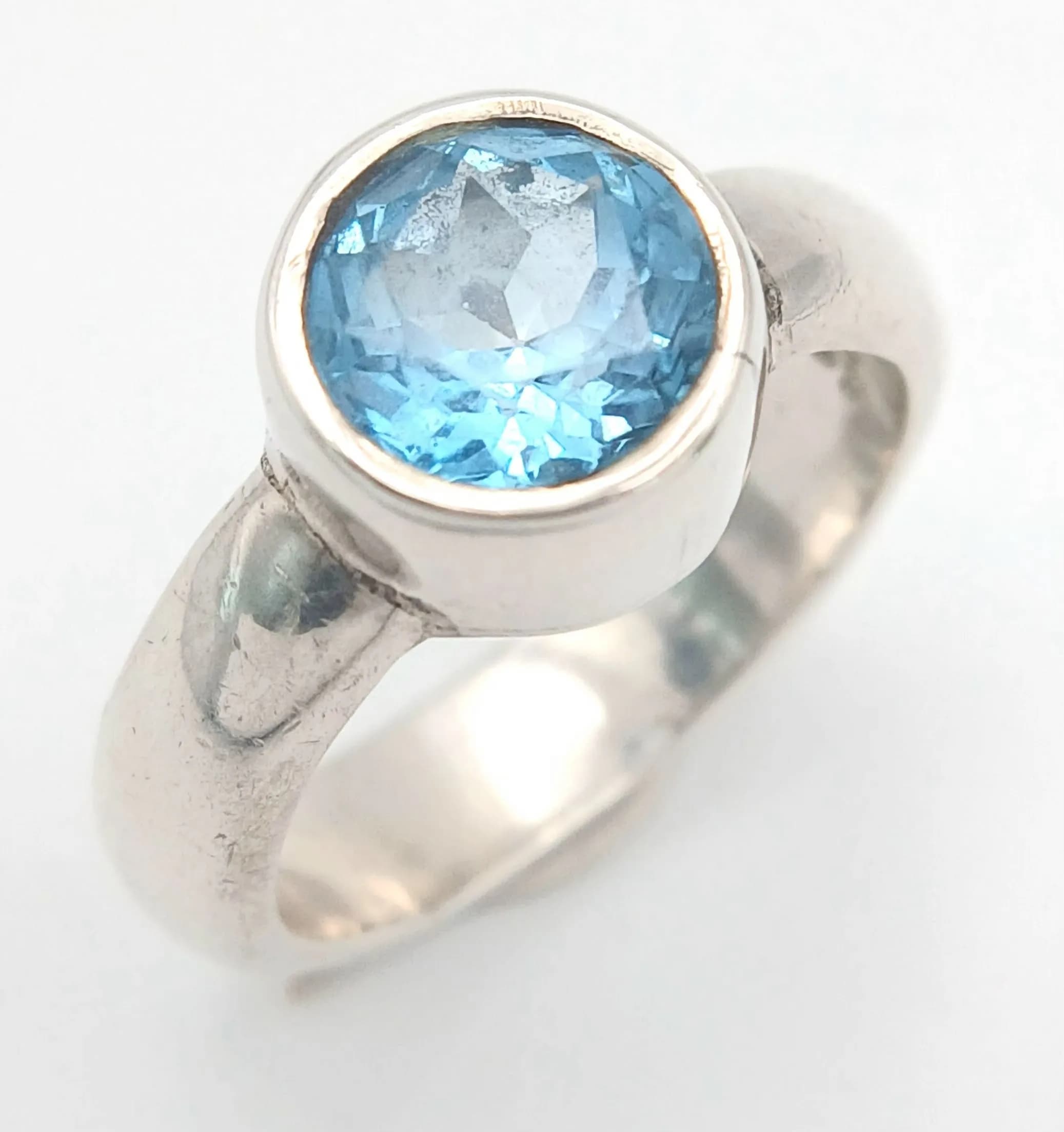 A Sterling Silver and Blue Topaz Ring Size K. The Ring is set with a 7mm Round Cut Blue Topaz, approximately 1.5 carat. Gross weight 5.02 grams